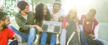 Photo of a group of people sitting outside, listening to music.