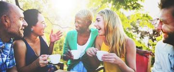 A group of people drinking coffee outside.