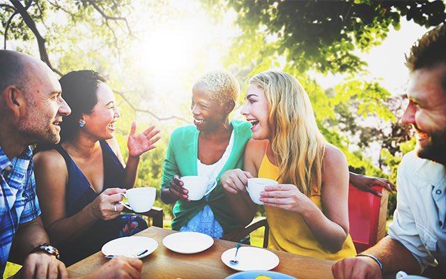 A group of people drinking coffee outside.